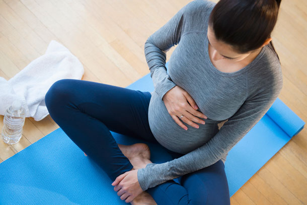 mujer embarazada en clase de yoga